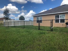 chain link fence company in cape coral florida with new fence install around new construction home